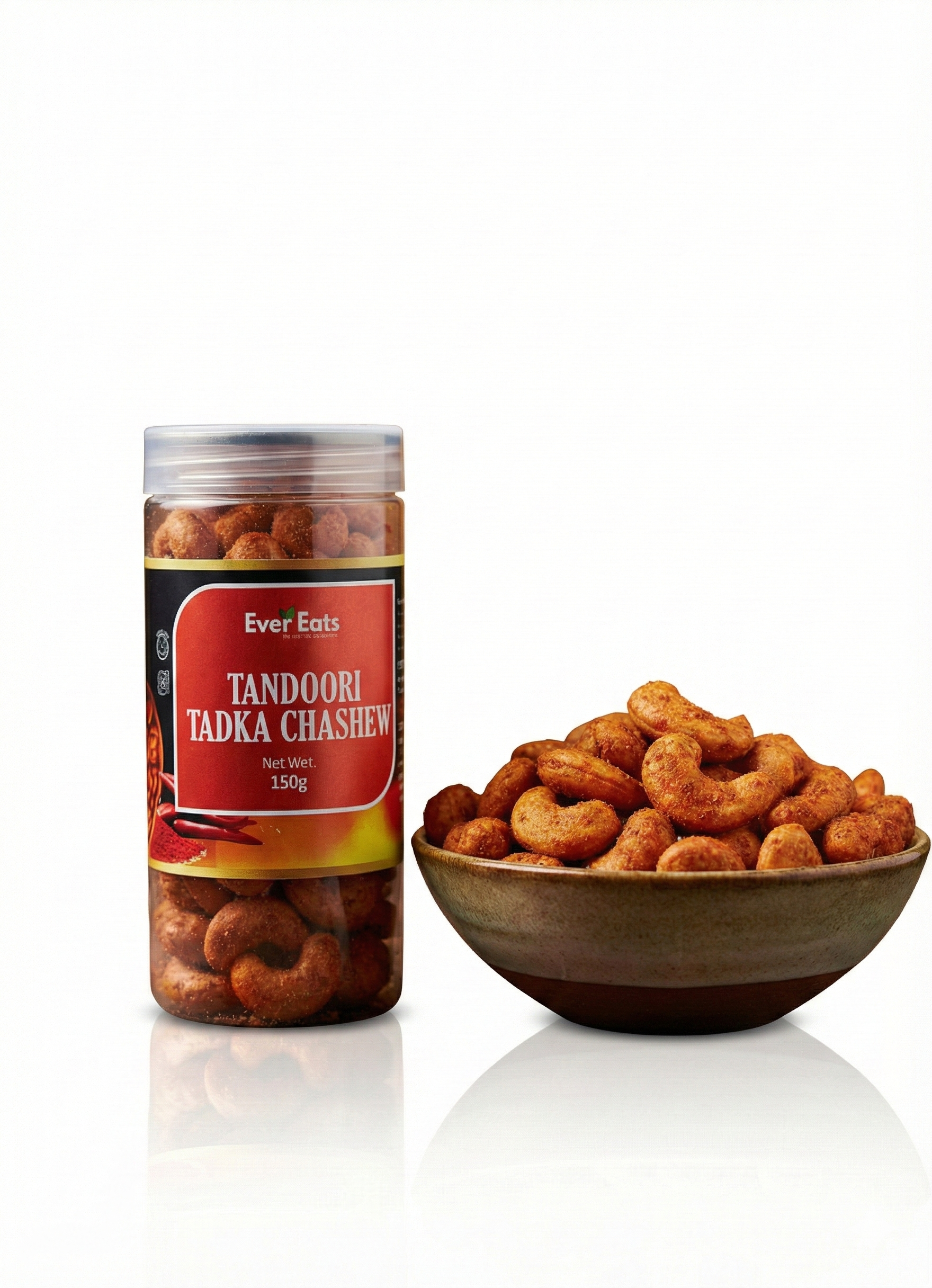 Jar of Tandoori Tadka Cashews with a bowl of cashews on a white background